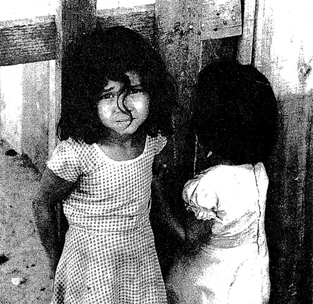 Black and white photo of two young children, one facing away from the camera, that was featured on the report's original cover.
