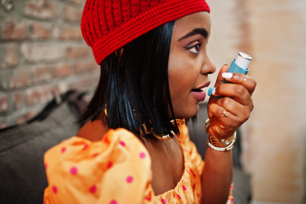 Young Black women using an asthma inhaler. (Image by ASphotofamily on Freepik)