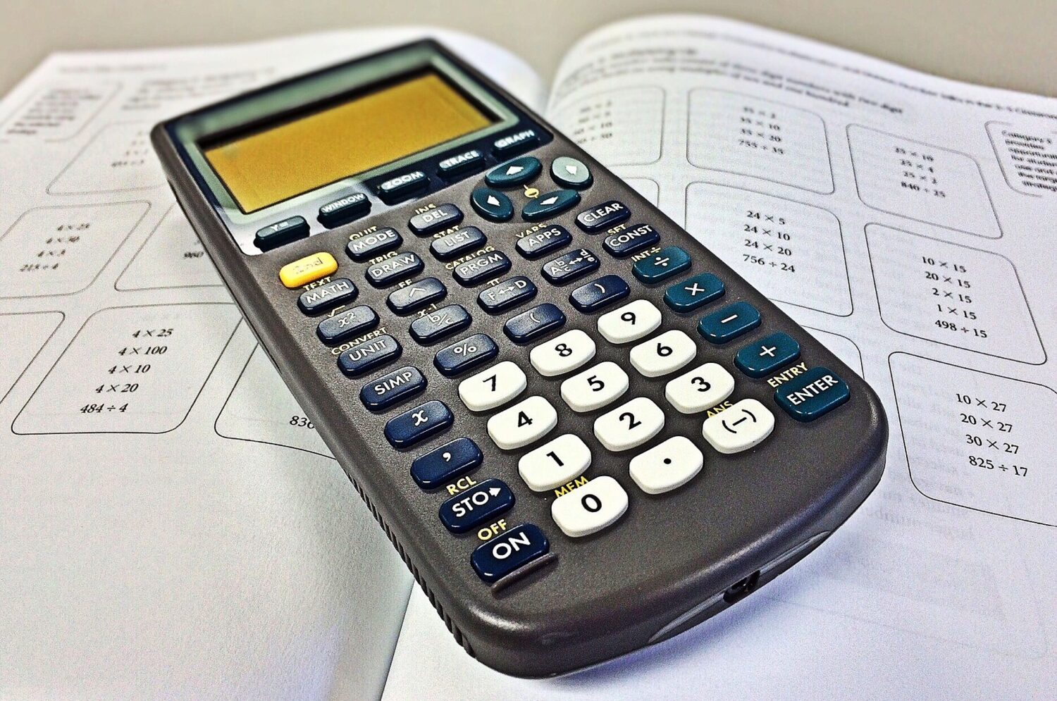Calculator on an open math textbook. (Photo by WOKANDAPIX from Pixabay)