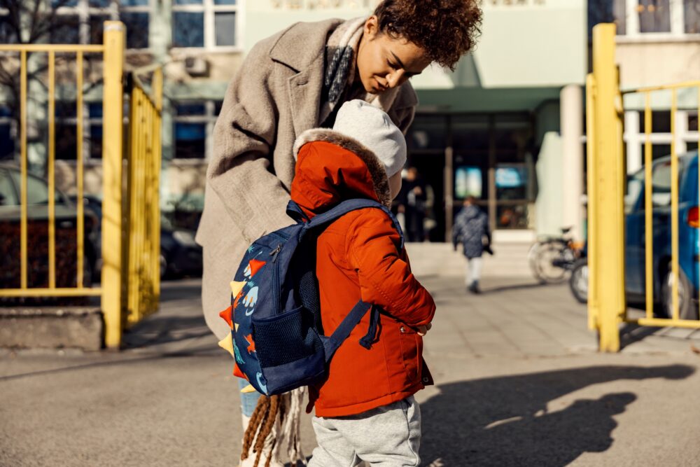 A parent drops a child off at school. (Photo by dusanpetkovic1, Adobe Stock)