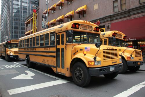 School buses on a New York City street. (Image by Maria Tsolakidou from Pixabay)