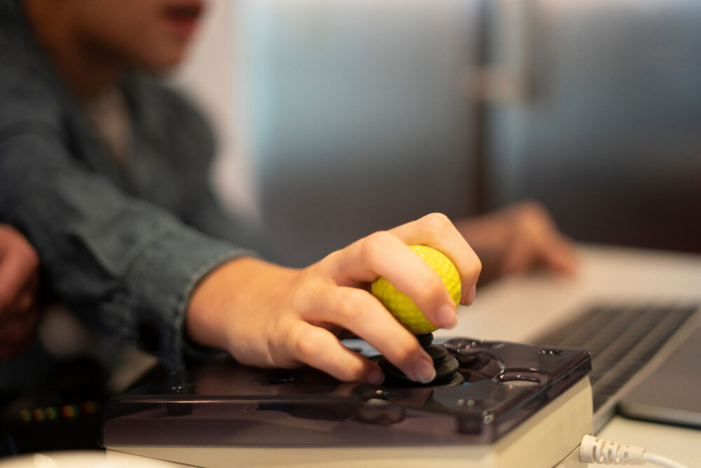 Hand of a teenage boy manipulating a joystick. (Photo by Cultura Creative, Adobe Stock)