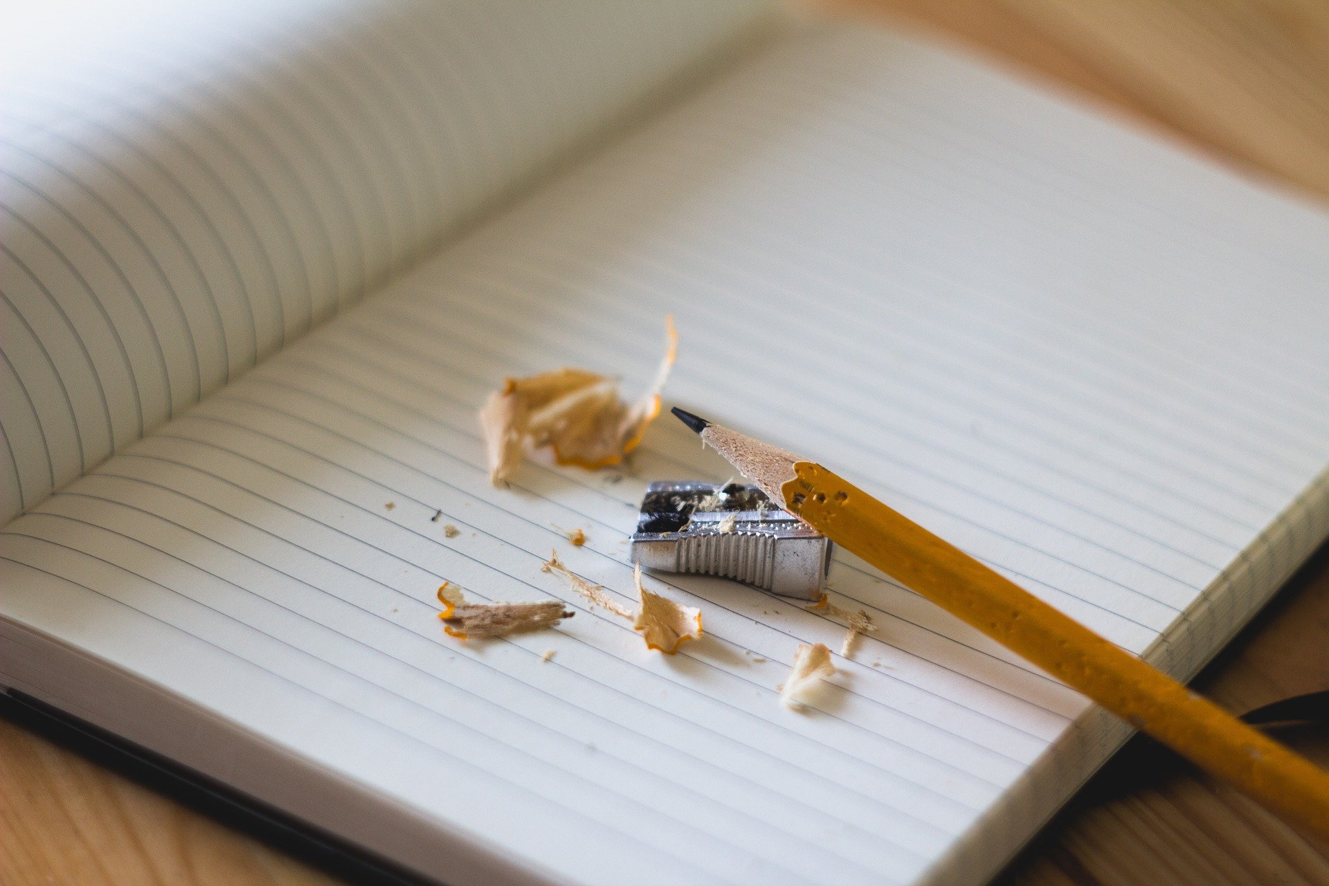 Pencil and sharpener on an open blank notebook. (Photo by Angelina Litvin via Unsplash)