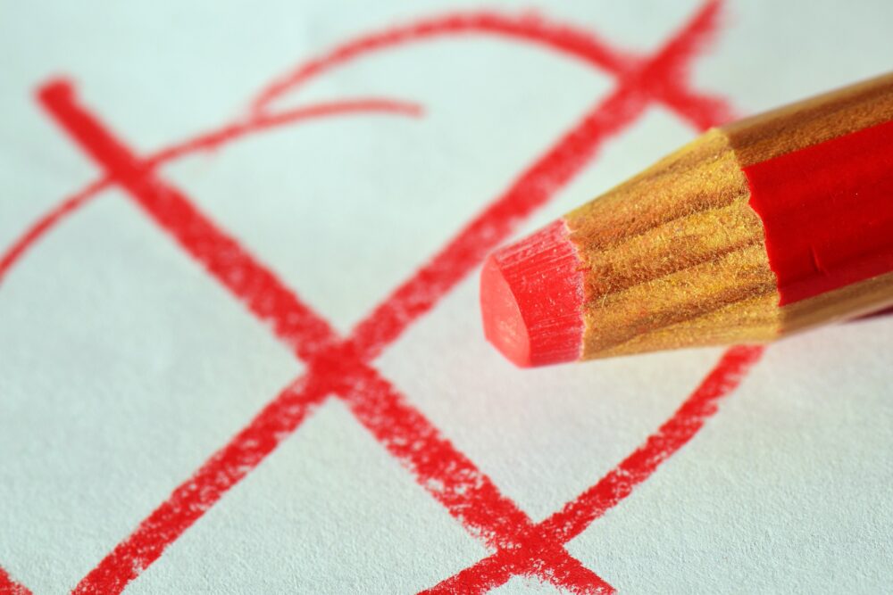 Close up of a red pencil making a large 