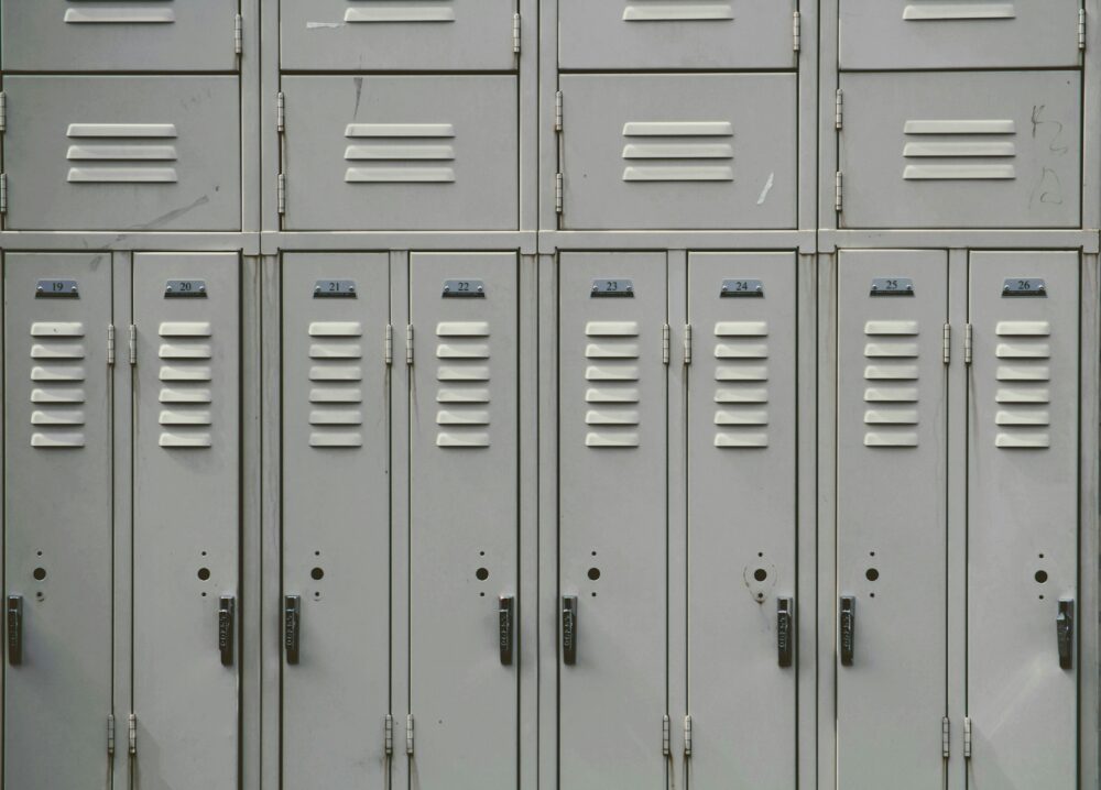 Gray lockers in a school hallway. (Photo by Joshua Hoehne on Unsplash)