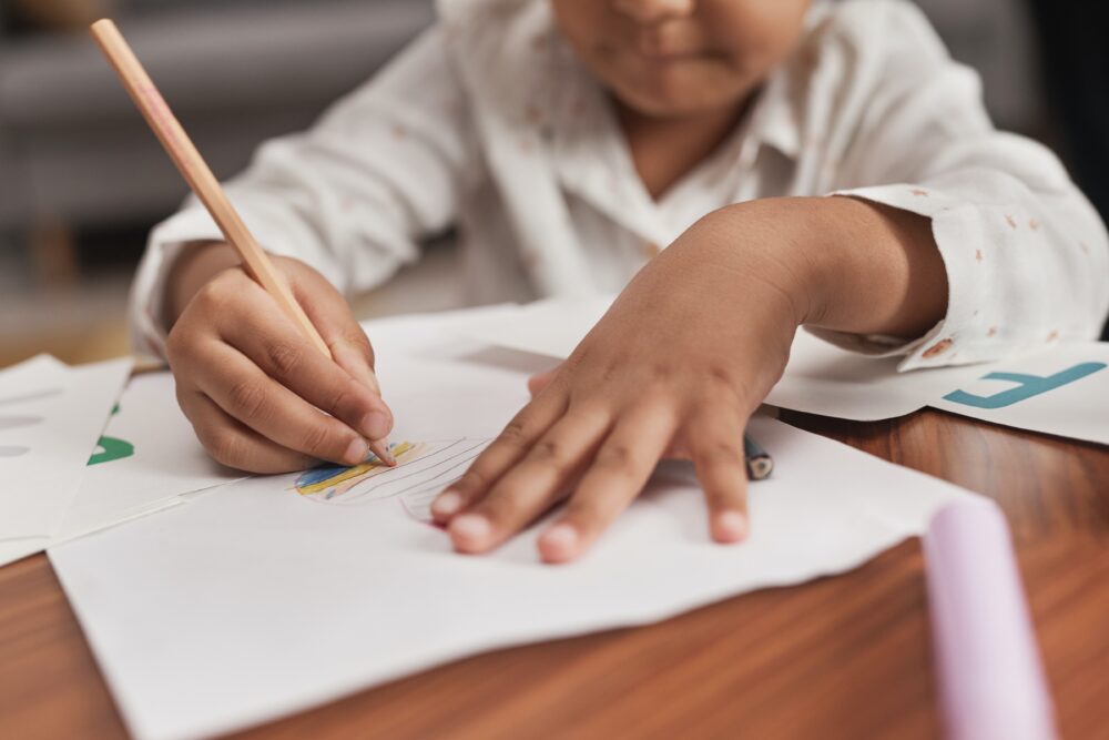 Close up of young student drawing with a colored pencil. (Photo by Werner Pfennig via Pexels)