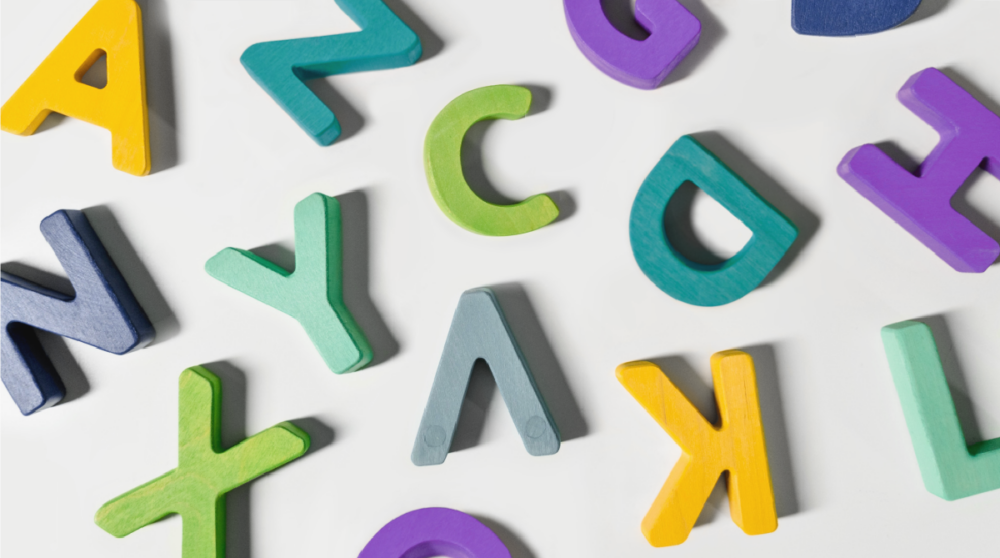 Colorful block letters scattered across a neutral background.