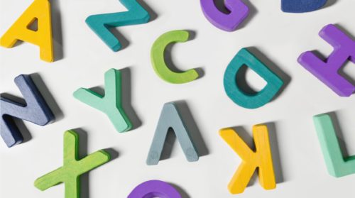 Colorful block letters scattered across a neutral background.