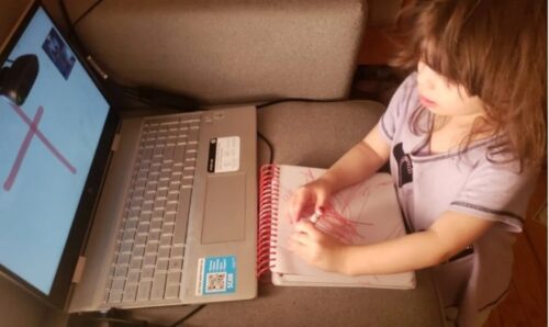 A 2-year-old child with autism on a Zoom lesson with her occupational therapist.