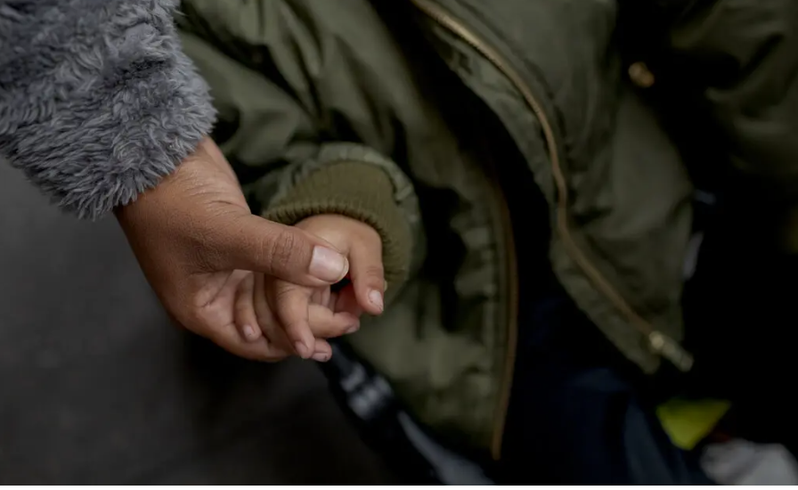 Image of child holding parent's hand.