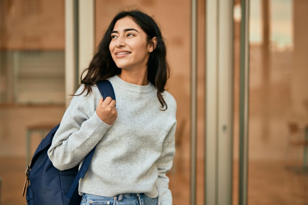 Smiling teen girl with a backpack. (Photo by Krakenimages.com, Adobe Stock)