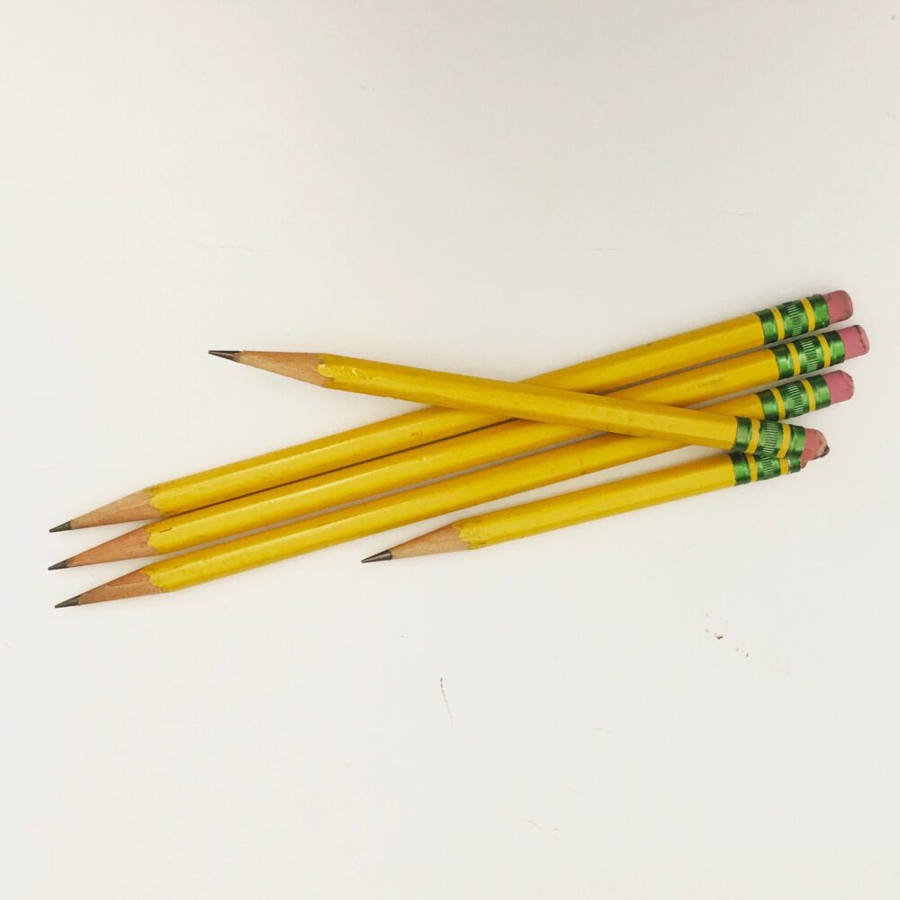 Five yellow pencils of varying lengths against a white background.