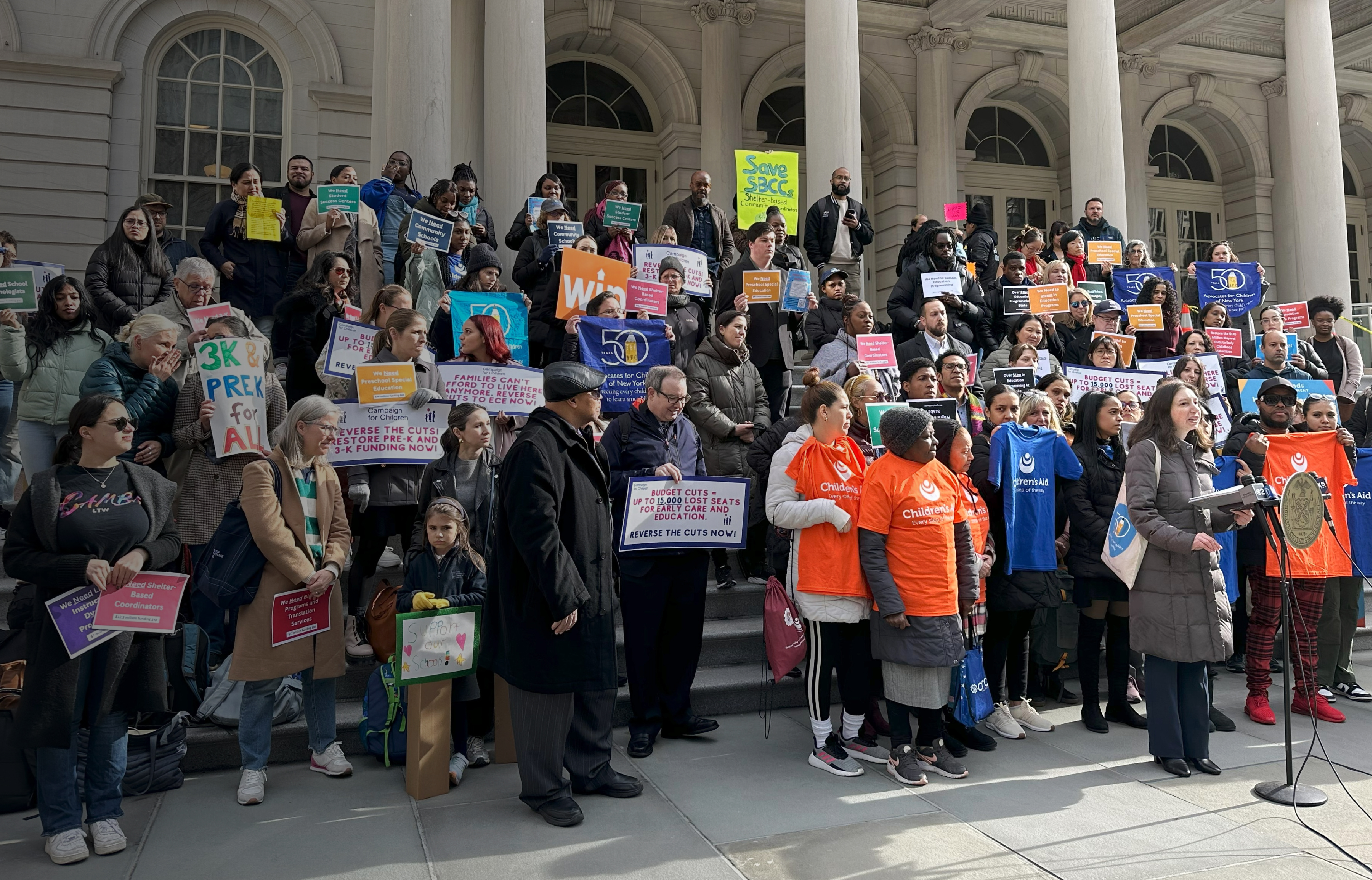 Members of the Emergency Coalition to Save Education Programs rally on the steps of City Hall prior to the March 2024 City Council hearing on the preliminary education budget.