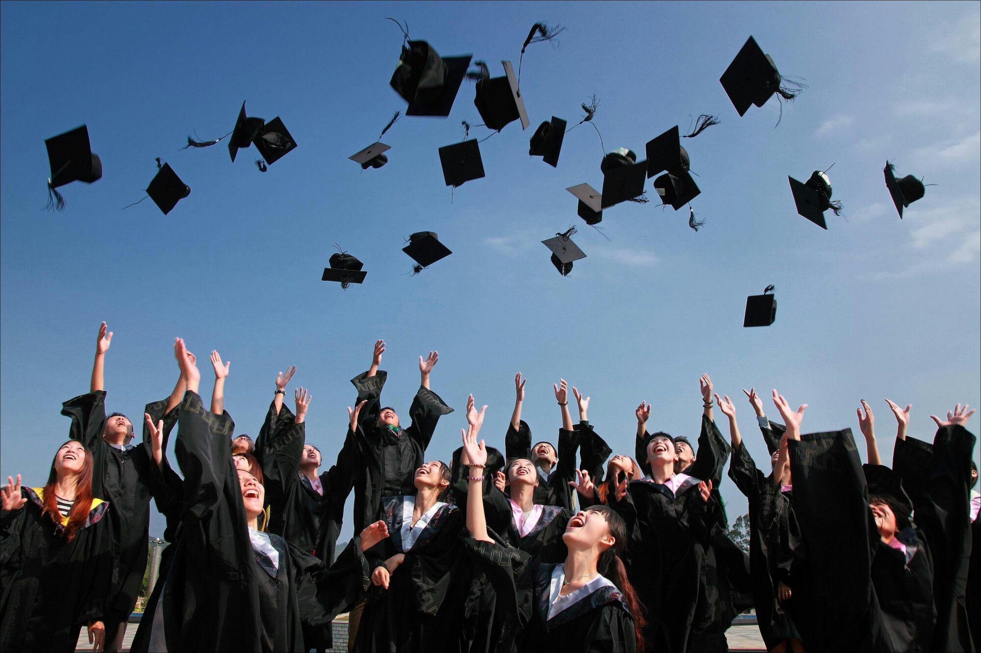 graduates throw their caps in the air