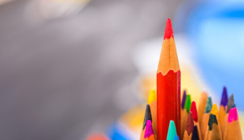 Selective focus colored pencils with red pencil sticking out (Photo by sorapop, Adobe Stock)