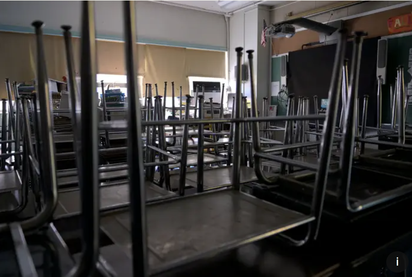 A classroom is empty with the lights off.