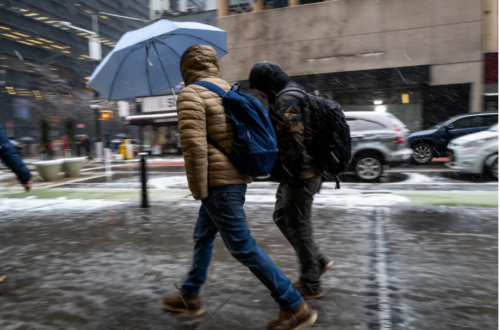 People walk through the blowing snow in Manhattan as a large winter storm makes its way across the area on Feb. 13 in New York City