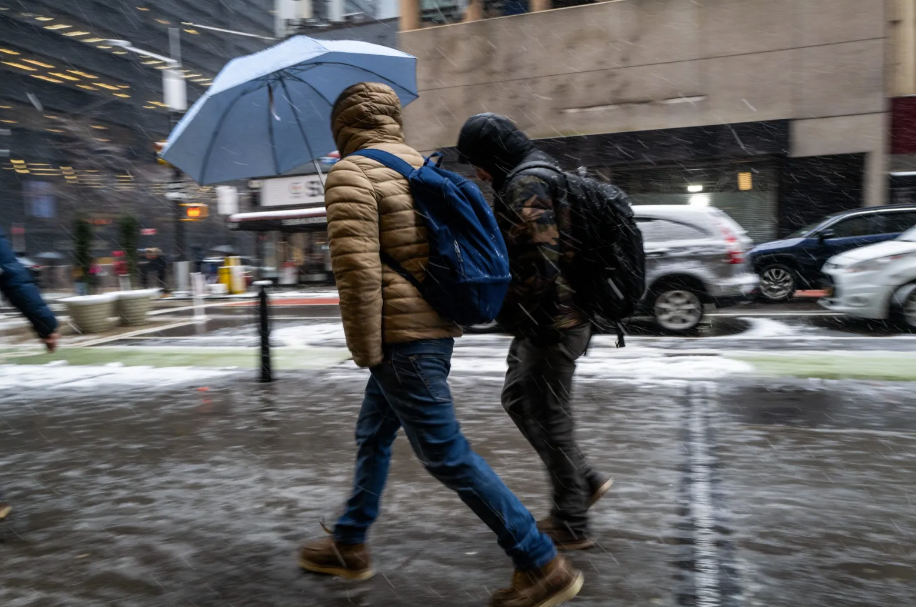 People walk through the blowing snow in Manhattan as a large winter storm makes its way across the area on Feb. 13 in New York City