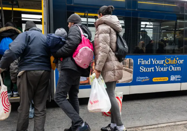 Migrants board a bus in New York City
