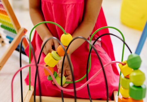 Midsection of a young girl playing with educational toys. (Photo by Yan Krukau from Pexels)