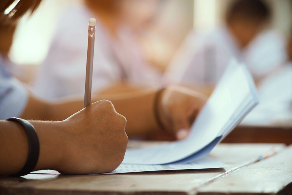 Closeup of student holding a pencil in class