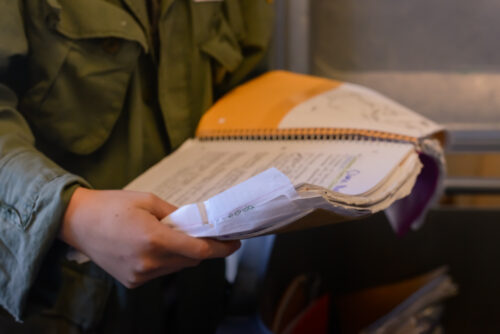 high school student holding used spiral notebook