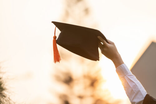Close up Graduate student put hands up and celebrating with grad