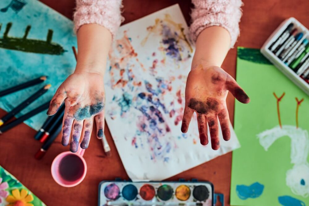 Preschooler showing painted colorful hands