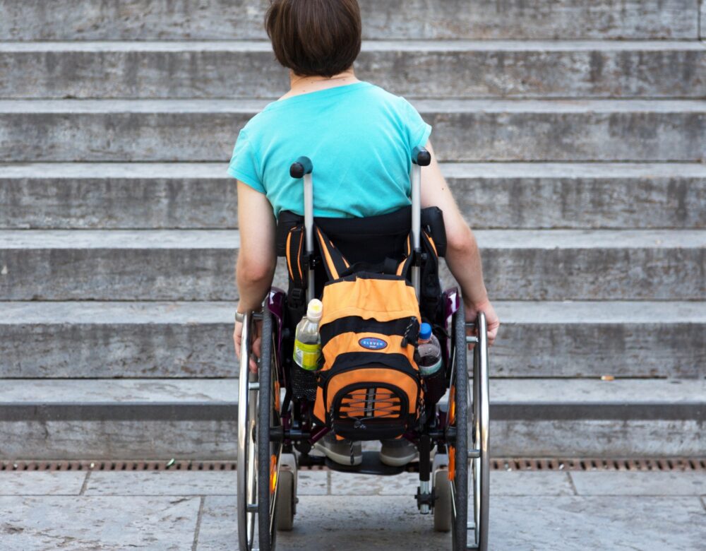 Student in a wheelchair faces a flight of stairs.