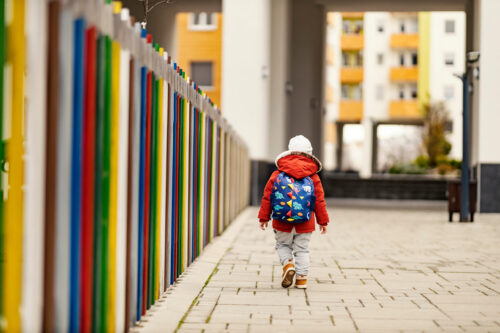 A little boy with a schoolbag going to preschool.