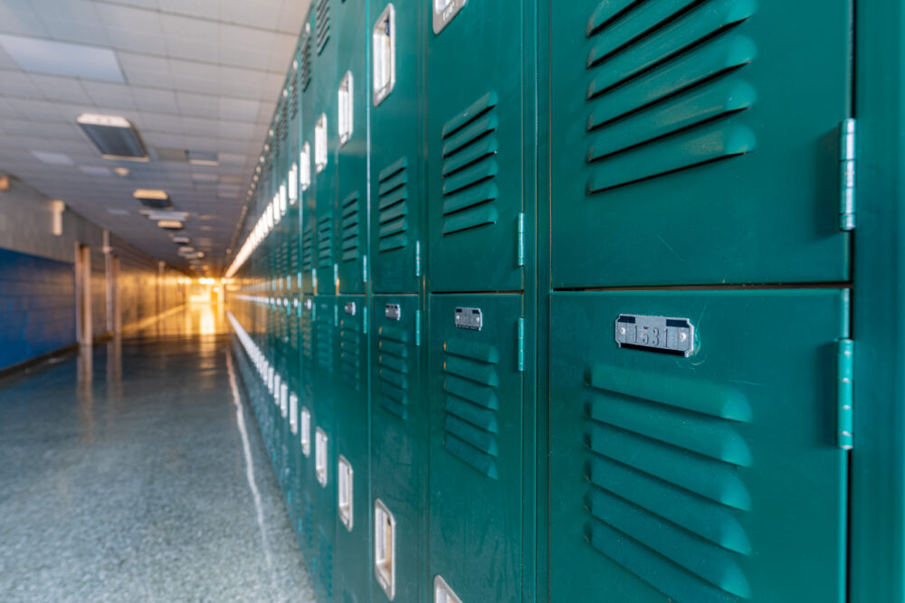 Green metal lockers along a nondescript hallway in a typical high school