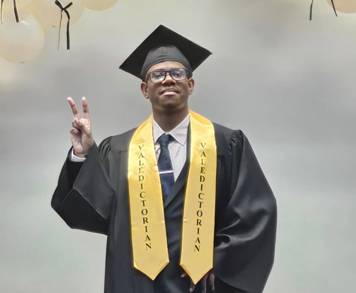 tozir poses with his graduation robes