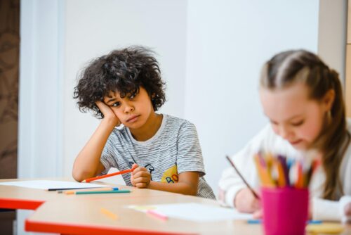 Young boy in a classroom, looking glum. (Photo by Anastasia Shuraeva via Pexels)