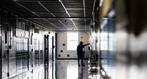 Man stands in an empty school hallway