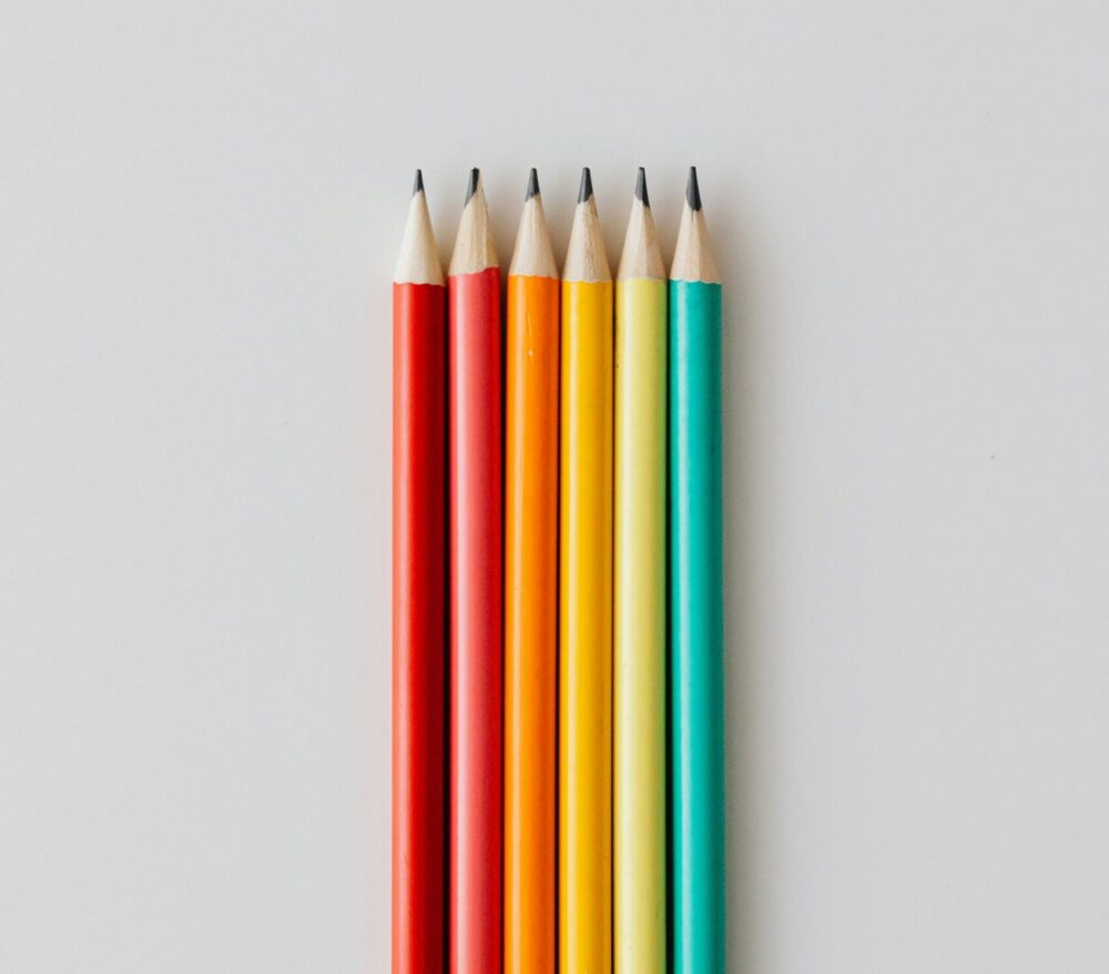 Six pencils neatly lined up in rainbow order.