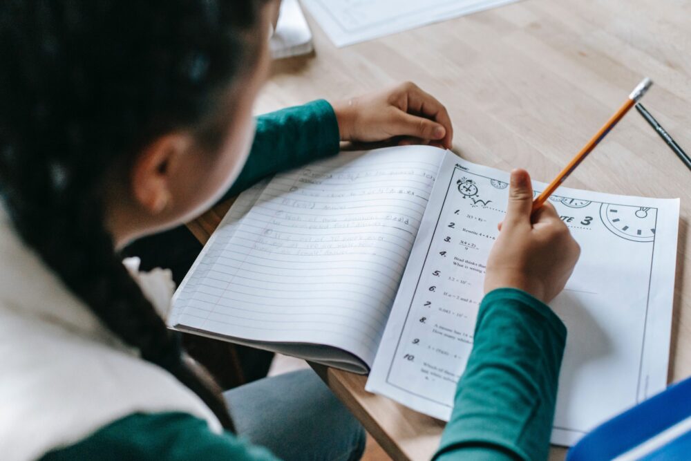 Rear shot of a student writing on a worksheet.