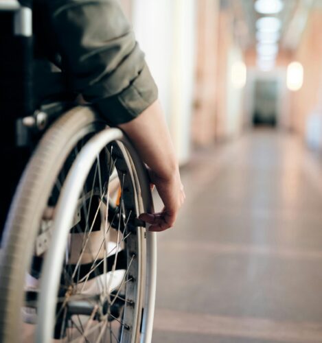 Person in a wheelchair rolls down a hallway.