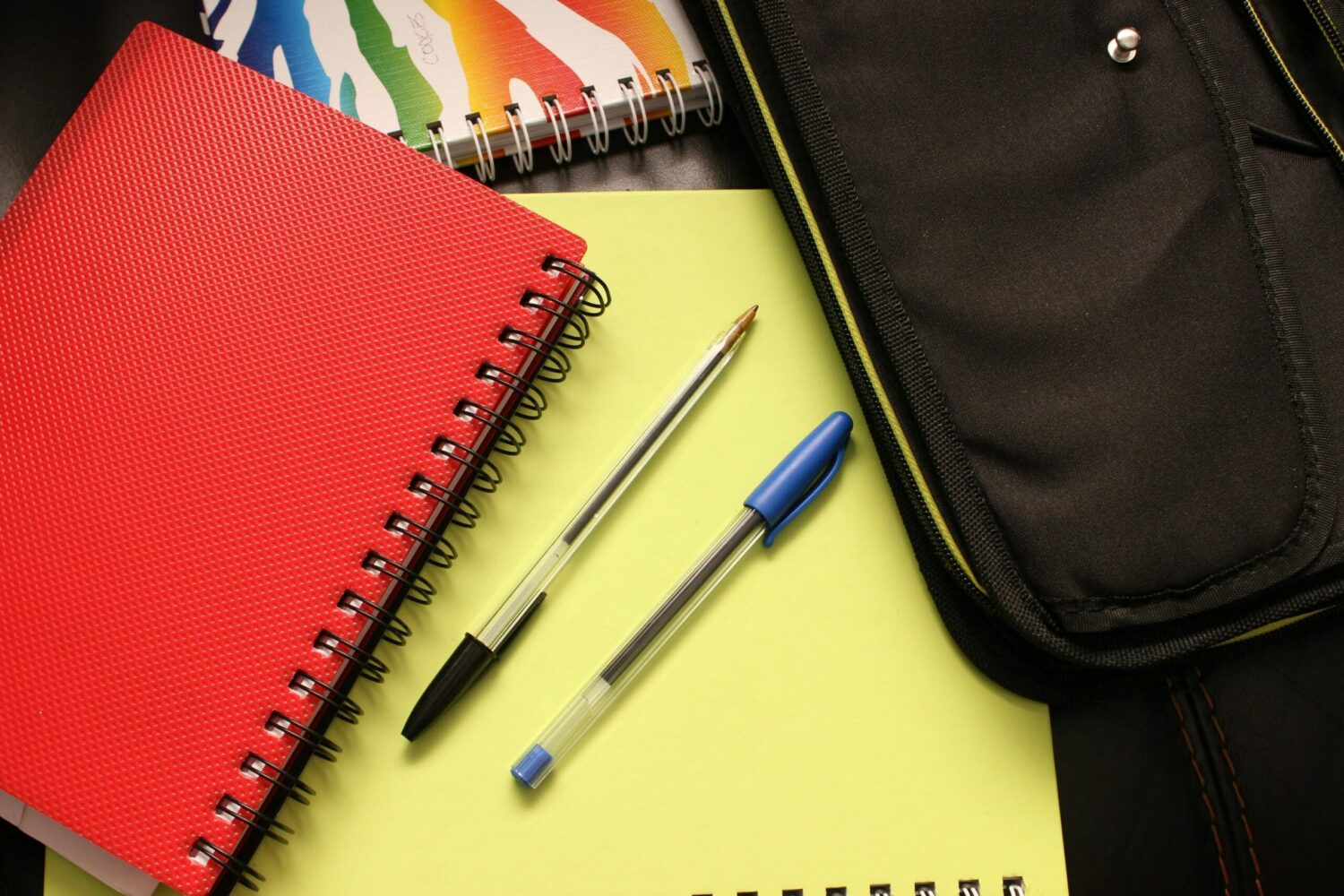 close-up of scattered notebooks and pens