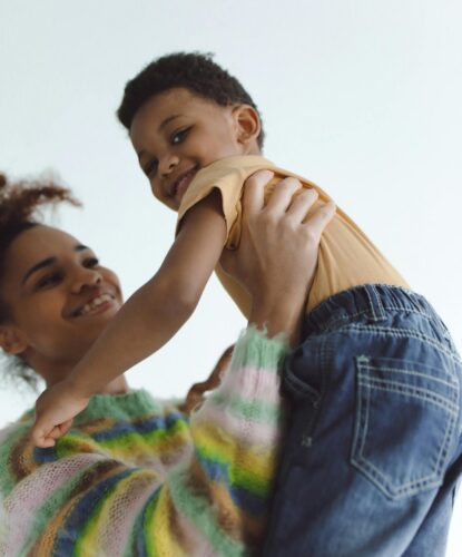 Smiling mother holding happy toddler
