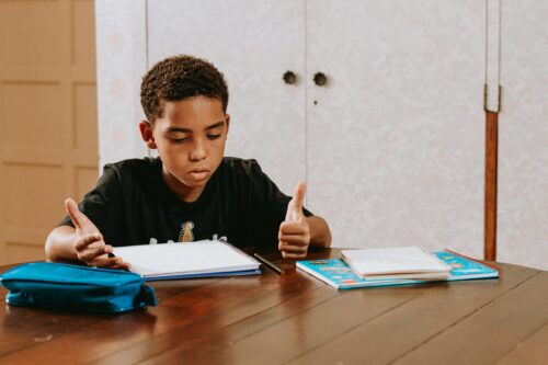 Boy sits at table doing homework