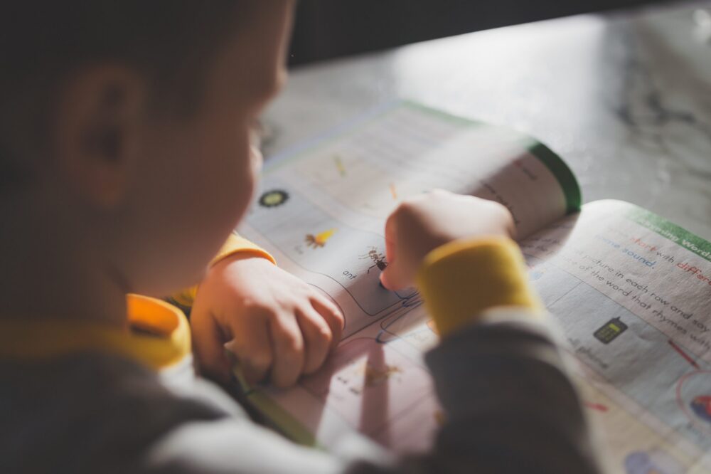 Close up of a young boy reading a textbook.