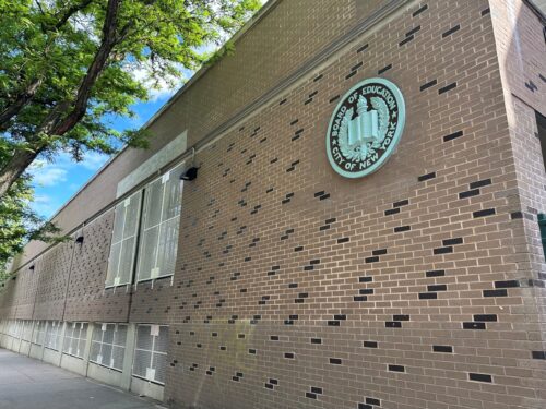 Side of an NYC DOE school building on a sunny day.