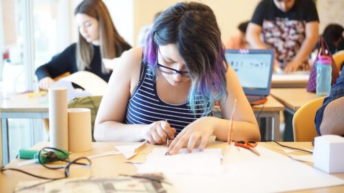 Teenage girl works on a technical project at her desk